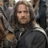 Viggo Mortensen jako Aragorn, w otoczeniu koni i innych postaci, w scenie z jednego z jego filmów.