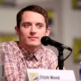 Elijah Wood, znany z wielu filmów, siedzi przy mikrofonie.
