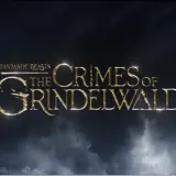 Złote litery tytułu "Fantastyczne zwierzęta: Zbrodnie Grindelwalda" na tle burzowych chmur.