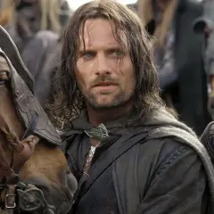 Viggo Mortensen jako Aragorn, w otoczeniu koni i innych postaci, w scenie z jednego z jego filmów.