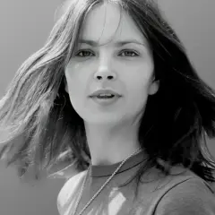 Portret młodej kobiety z rozwianymi włosami. Zastanawiamy się, ile lat ma Anna Dymna na tym zdjęciu.