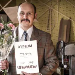 Adam Woronowicz z bukietem i dyplomem, jakby po premierze jednego z jego filmów.