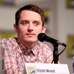 Elijah Wood, znany z wielu filmów, siedzi przy mikrofonie.