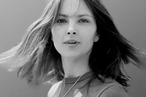 Portret młodej kobiety z rozwianymi włosami. Zastanawiamy się, ile lat ma Anna Dymna na tym zdjęciu.