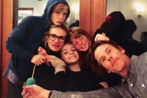 Julia Roberts z dziećmi, uśmiechnięci i blisko siebie, tworzą radosną rodzinną chwilę.