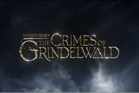 Złote litery tytułu "Fantastyczne zwierzęta: Zbrodnie Grindelwalda" na tle burzowych chmur.