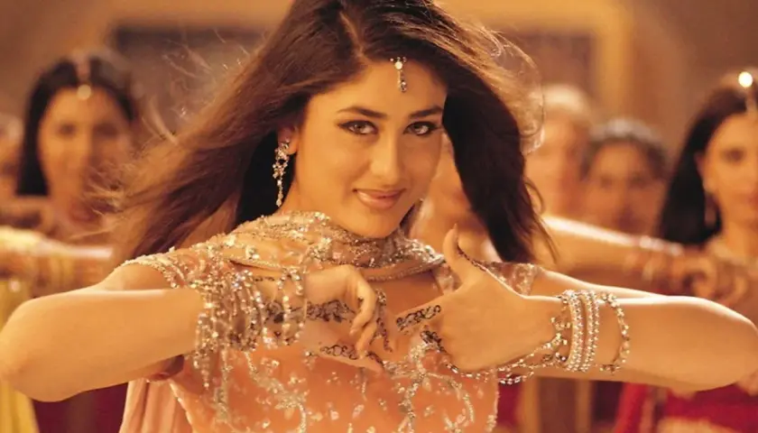 Tancerka w stroju bollywood, ozdobiona biżuterią i henną, wykonuje taniec.