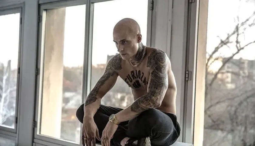Mateusz Damięcki w filmach często wciela się w role z charakterem. Tutaj w stylizacji z tatuażami i złotym łańcuchem.