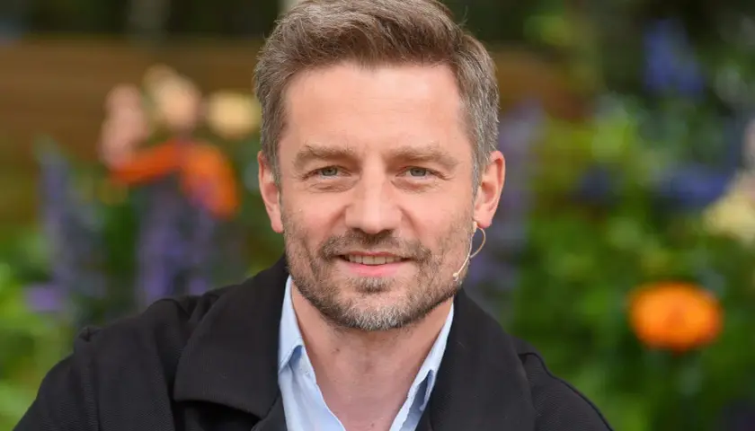 Marcin Rogacewicz, znany z ról w serialach, prezentuje się z uśmiechem. Jego wiek dodaje mu uroku.