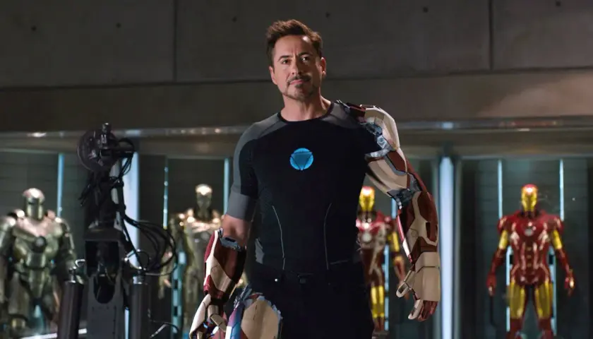 Tony Stark, czyli Iron Man, w swojej zbrojowni, otoczony przez kilka swoich pancerzy.