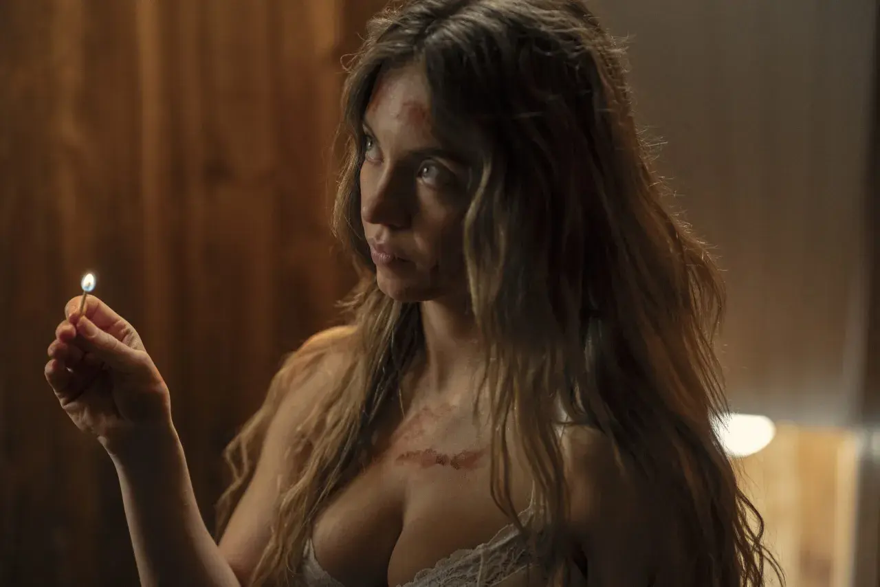 Sydney Sweeney z zapaloną zapałką w dłoni, z widocznymi śladami na skórze.