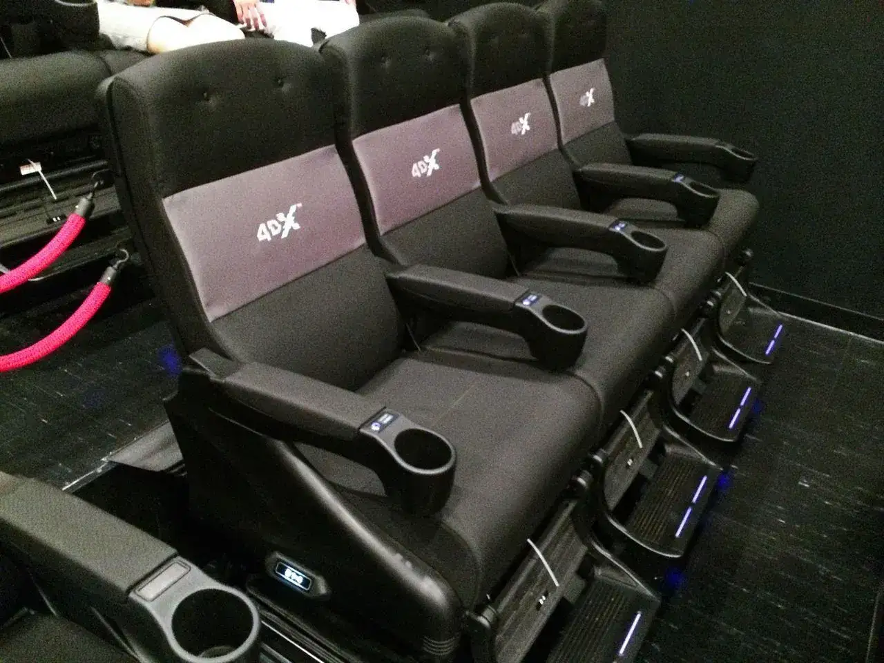 Fotele kinowe 4DX, z podnóżkami i uchwytami na napoje. Ciekawi Cię 4dx co to? To kinowe doświadczenie z dodatkowymi efektami.