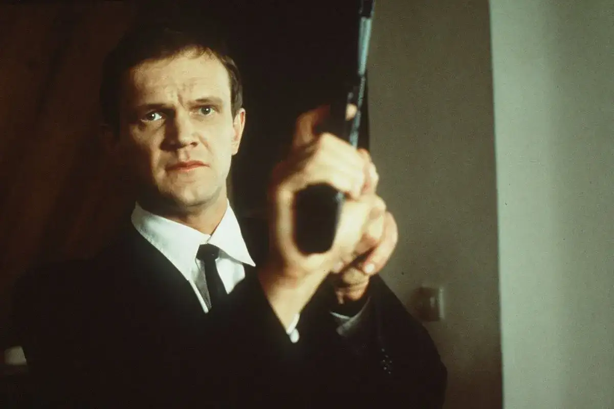 Cezary Pazura w filmach często wciela się w role twardzieli. Tutaj w garniturze i z pistoletem, gotowy do akcji.
