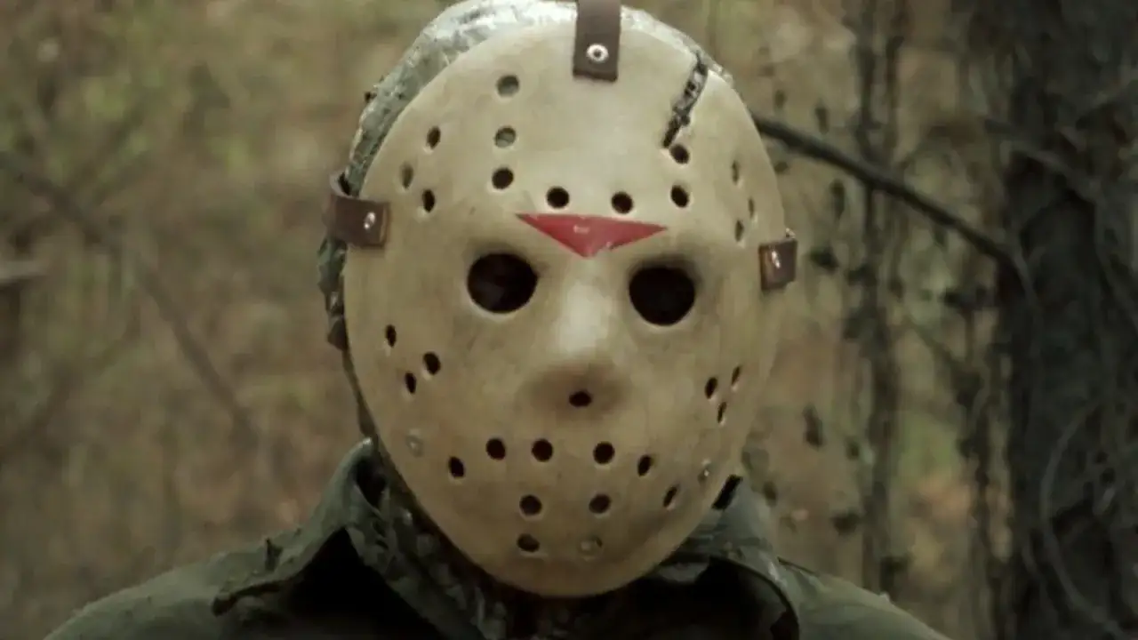 Jason Voorhees w swojej charakterystycznej masce hokejowej, otoczony mrocznym lasem.